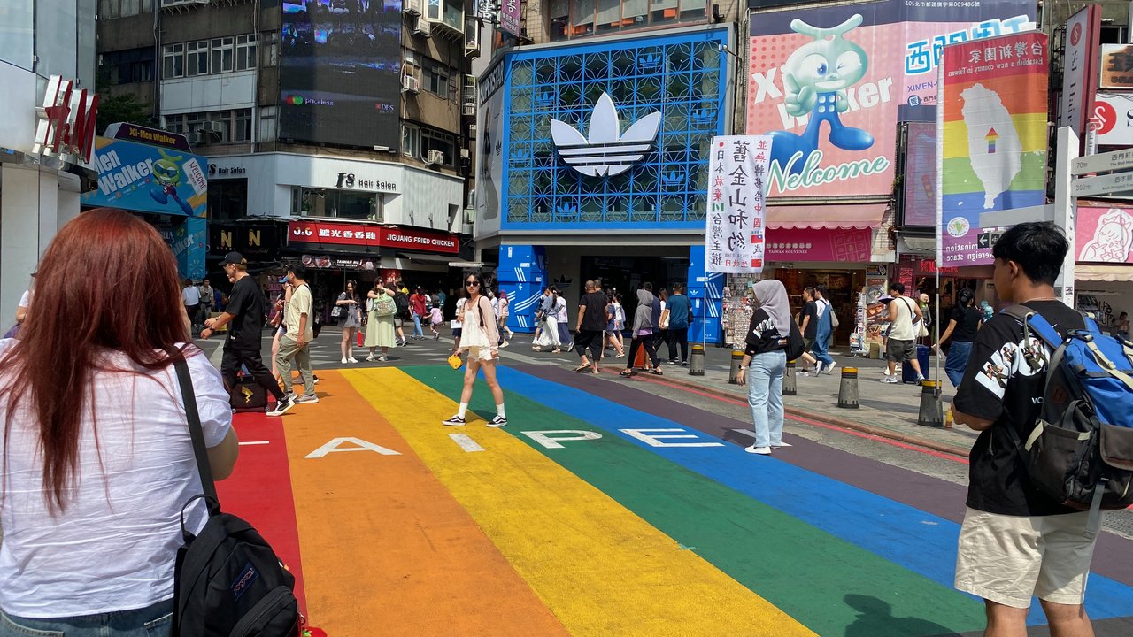 Pedestrians crossing the rainbow crosswalk in Ximending, Taipei